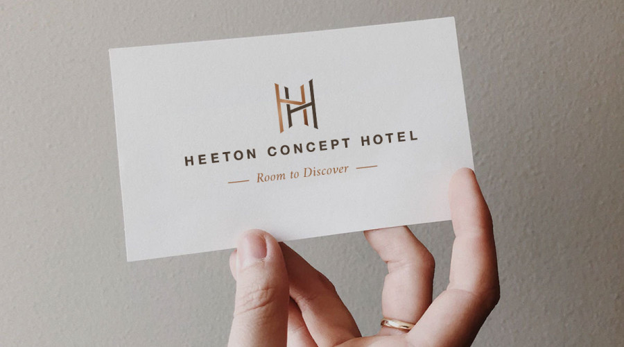 A Heeton Concept Hotel logo and tagline that reads “Room to Discover” on a business card