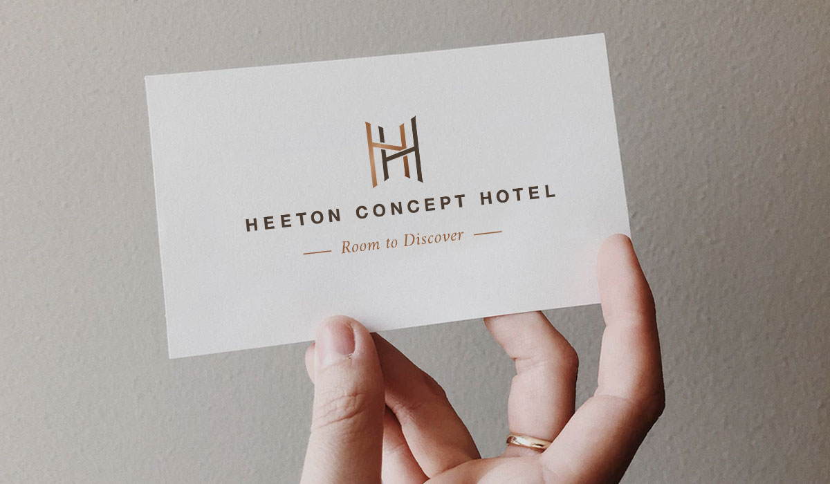A Heeton Concept Hotel logo and tagline that reads “Room to Discover” on a business card